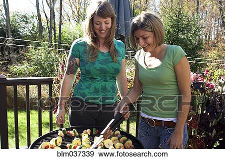 Women grilling kebabs in backyard View Large Photo Image Stock Photo - Women grilling kebabs in backyard. Fotosearch