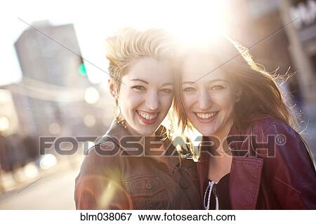Women hugging on sunny city sidewalk View Large Photo Image Stock Photo - Women hugging on sunny city sidewalk. Fotosearch