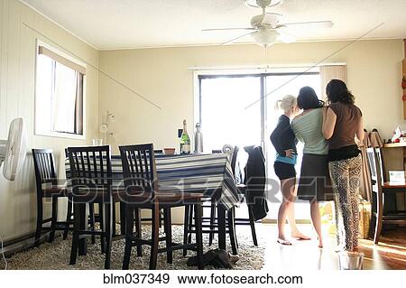Stock Photo - Women standing in dining room. Fotosearch