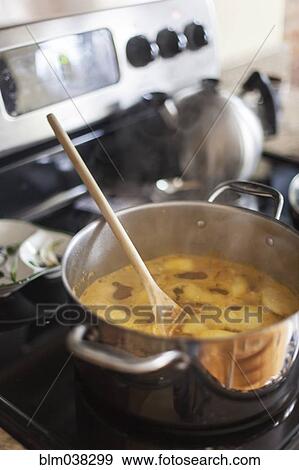 Wooden spoon in pot of broth View Large Photo Image Stock Photo - Wooden spoon in pot of broth. Fotosearch