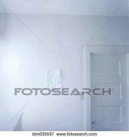 Stock Photo - Wrinkled paper on empty white wall. Fotosearch