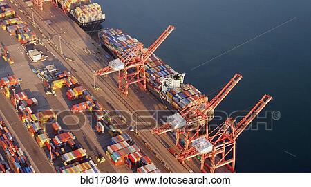 Stock Photograph - Aerial view of containers and cranes in industrial shipyard. Fotosearch
