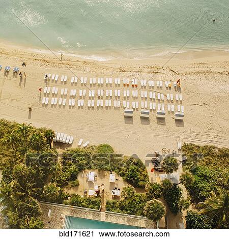 Stock Image - Aerial view of hotel pool and tropical beach. Fotosearch