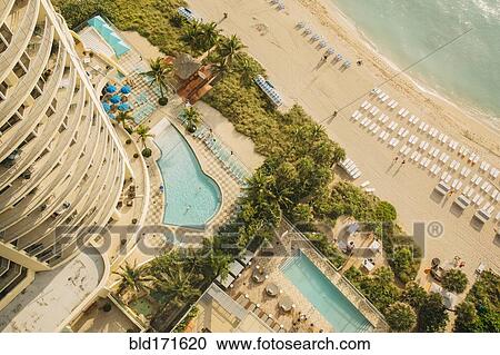 Stock Image - Aerial view of hotel pools and tropical beach. Fotosearch