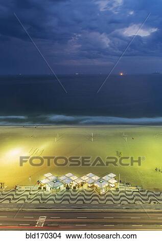 Picture - Aerial view of market on beach under cloudy sky. Fotosearch