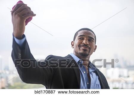 Stock Photo - African American businessman taking selfie with cell phone. Fotosearch