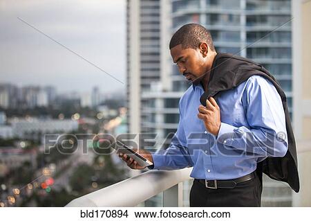 African American businessman using cell phone on urban balcony View Large Photo Image Picture - African American businessman using cell phone on urban balcony. Fotosearch