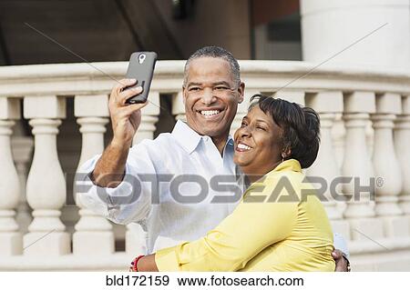Stock Photo - African American couple taking selfie outdoors. Fotosearch