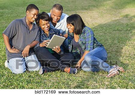 African American family using digital tablet on grass View Large Photo Image Stock Photo - African American family using digital tablet on grass. Fotosearch