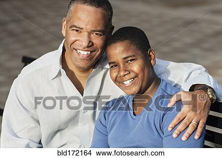 African American father and son hugging on bench View Large Photo Image Picture - African American father and son hugging on bench. Fotosearch