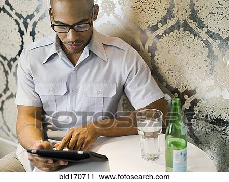 African American man using digital tablet in restaurant View Large Photo Image Stock Image - African American man using digital tablet in restaurant. Fotosearch