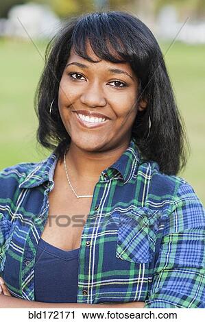 Stock Image - African American teenage girl smiling outdoors. Fotosearch