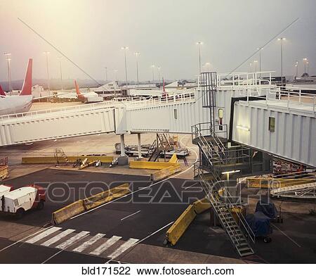 Airplane and elevated walkway on airport runway View Large Photo Image Stock Image - Airplane and elevated walkway on airport runway. Fotosearch