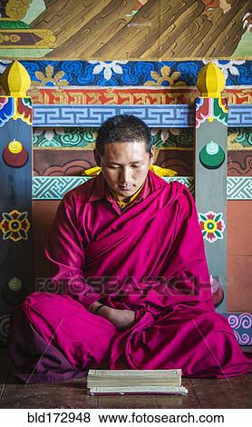 Stock Photo - Asian monk reading on temple floor. Fotosearch