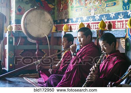 Stock Image - Asian monks playing instruments on temple floor. Fotosearch