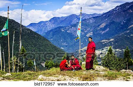 Stock Photo - Asian monks with flag on remote hilltop. Fotosearch