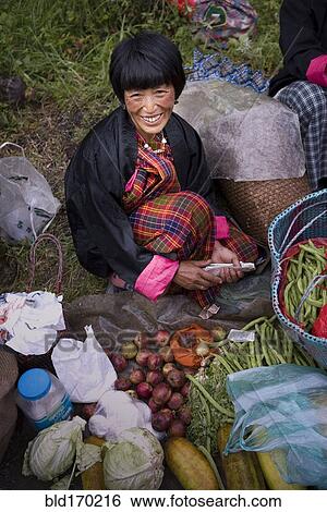 Stock Photograph - Asian woman smiling at market. Fotosearch