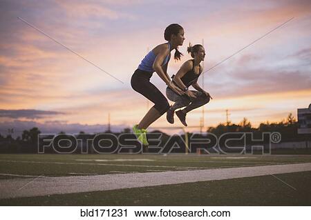 Athletes jumping on sports field View Large Photo Image Stock Image - Athletes jumping on sports field. Fotosearch