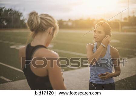 Athletes listening to mp3 players on sports field View Large Photo Image Stock Image - Athletes listening to mp3 players on sports field. Fotosearch