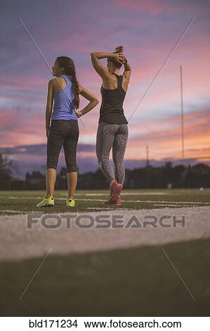 Picture - Athletes resting on sports field. Fotosearch
