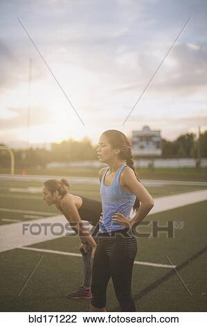 Stock Image - Athletes resting on sports field. Fotosearch