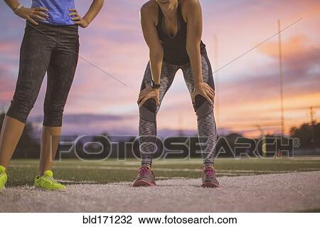 Stock Image - Athletes resting on sports field. Fotosearch