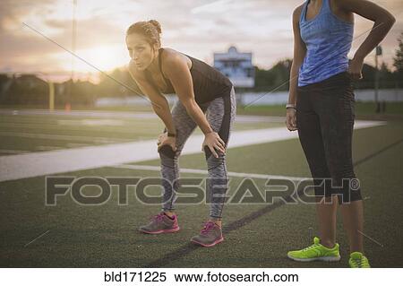 Stock Photography - Athletes resting on sports field. Fotosearch