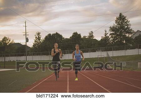 Athletes running on track in sports field View Large Photo Image Picture - Athletes running on track in sports field. Fotosearch
