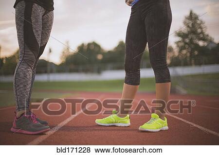 Stock Photo - Athletes standing on track on sports field. Fotosearch