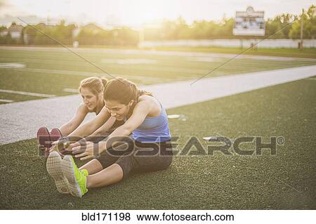 Stock Photo - Athletes stretching on sports field. Fotosearch