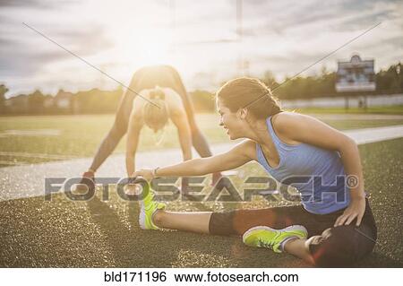 Athletes stretching on sports field View Large Photo Image Stock Photograph - Athletes stretching on sports field. Fotosearch