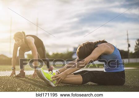 Stock Photography - Athletes stretching on sports field. Fotosearch