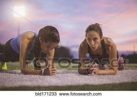 Stock Image - Athletes working out on sports field. Fotosearch
