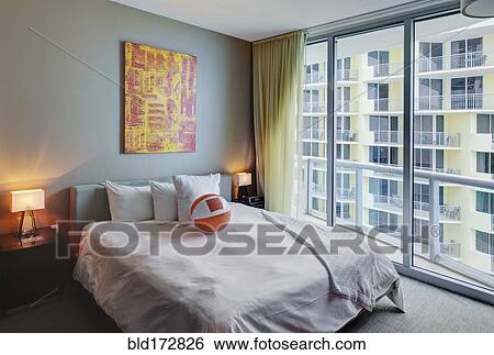 Stock Photograph - Beach ball on bed in hotel room. Fotosearch