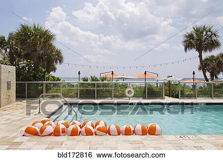 Stock Photograph - Beach balls in swimming pool. Fotosearch