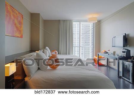 Stock Photo - Beach balls on bed in hotel room. Fotosearch