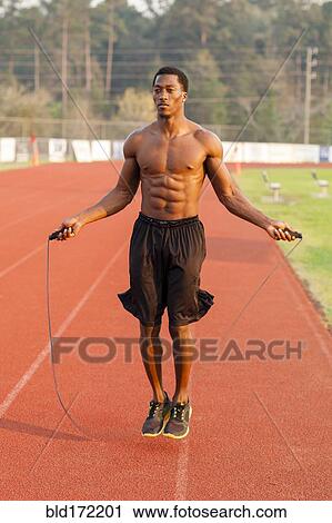 Black athlete jumping rope on track in sports field View Large Photo Image Stock Image - Black athlete jumping rope on track in sports field. Fotosearch
