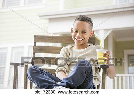 Black boy drinking orange juice in backyard View Large Photo Image Stock Image - Black boy drinking orange juice in backyard. Fotosearch