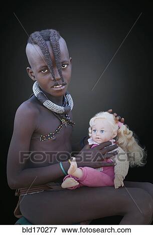 Stock Photo - Black girl playing with baby doll. Fotosearch