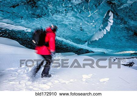 Stock Image - Blurred view of hiker walking in ice cave. Fotosearch