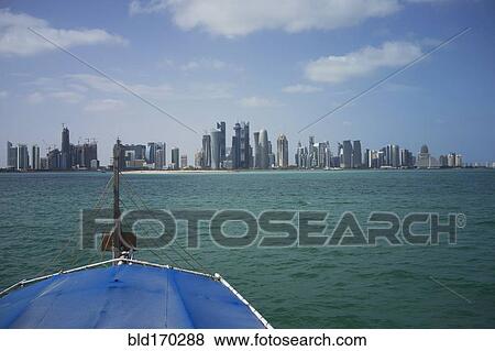 Stock Photo - Boat sailing towards Doha harbor, Doha, Qatar. Fotosearch