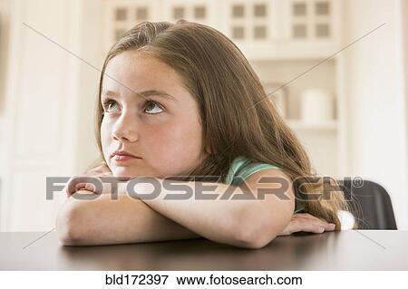 Stock Photo - Bored Caucasian girl leaning on table. Fotosearch
