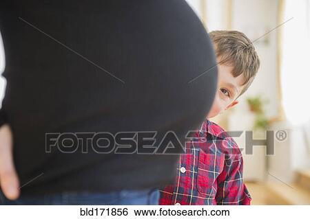 Stock Photograph - Boy admiring belly of pregnant mother. Fotosearch