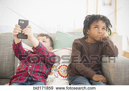 Stock Photo - Boy with cell phone ignoring friend. Fotosearch