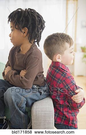 Stock Photo - Boys arguing on living room sofa. Fotosearch