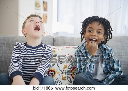 Boys laughing on living room sofa View Large Photo Image Stock Photography - Boys laughing on living room sofa. Fotosearch