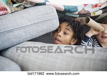 Stock Image - Boys playing in pillow fort. Fotosearch