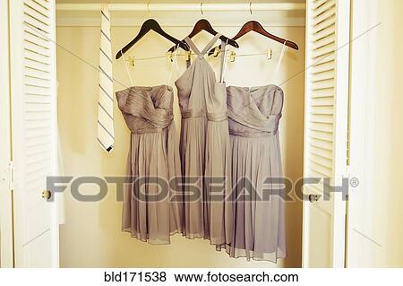 Bridesmaid dresses hanging in closet View Large Photo Image Stock Photo - Bridesmaid dresses hanging in closet. Fotosearch
