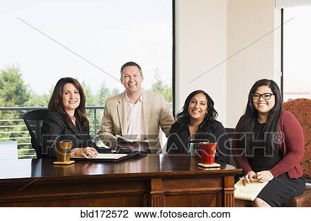 Stock Image - Business people smiling in office. Fotosearch
