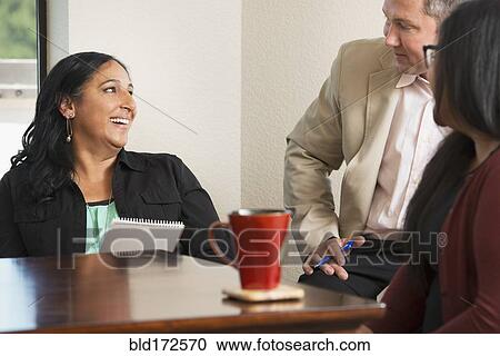 Stock Image - Business people talking in office. Fotosearch